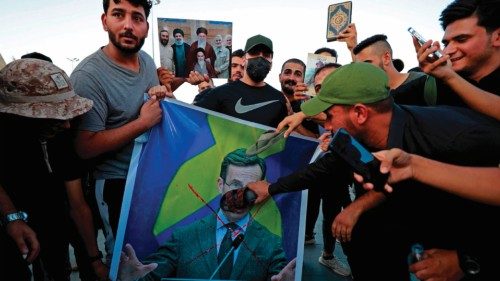 Supporters of the former paramilitary group Hashd al-Shaabi hold a poster depicting Swedish Prime ...