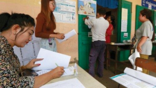 epa10761435 Cambodian officials prepare an information poster at a polling station in Phnom Penh, ...