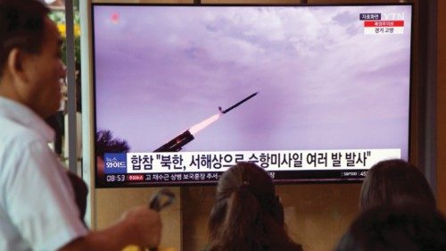 epa10761220 People watch a news report on a North Korean cruise missile launch at a station in ...