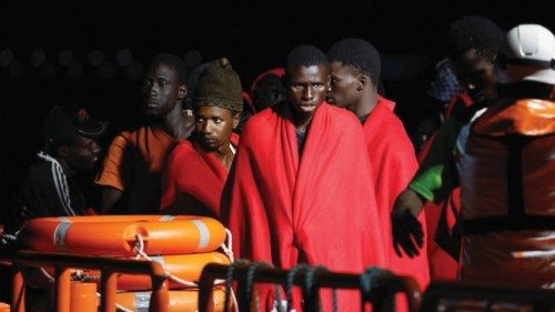 Migrants wait to disembark from a Spanish coast guard vessel, in the port of Arguineguin, in the ...