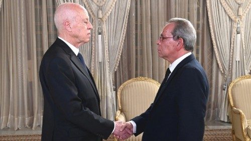 Tunisia's President Kais Saied shakes hands with newly appointed Tunisian Prime Minister Ahmed ...