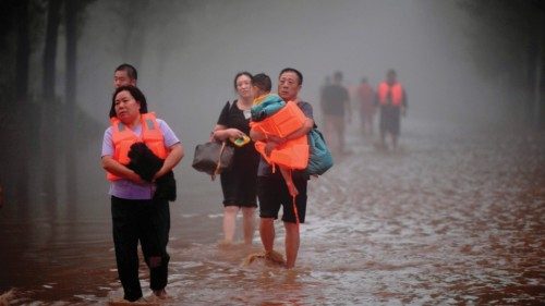 This photo taken on August 1, 2023 shows people evacuating from a flooded area after heavy rains in ...