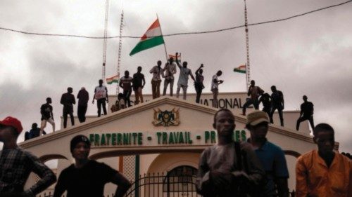TOPSHOT - Protesters hold a Niger flag during a demonstration on independence day in Niamey on ... TOPSHOT - Protesters hold a Niger flag during a demonstration on independence day in Niamey on ...