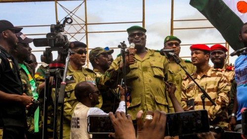 Members of a military council that staged a coup in Niger attend a rally at a stadium in Niamey, ...
