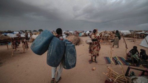 A sudanese man who fled the conflict in Geneina, in Sudan's Darfur region, carries empty jerrycans, ...