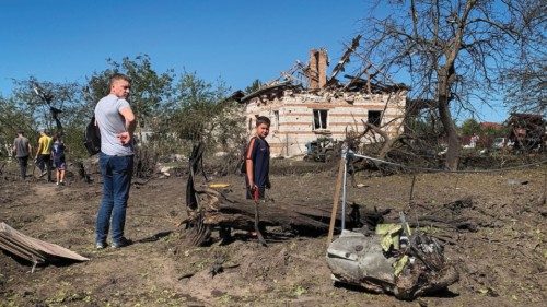 Local residents look at a part of a missile as they stand near residential buildings destroyed ... Local residents look at a part of a missile as they stand near residential buildings destroyed ...