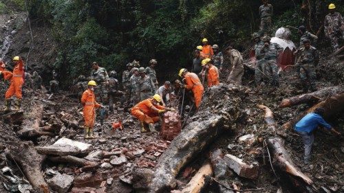 Rescue workers remove the debris as a search operation continues in the aftermath of a landslide ...