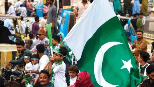 A boy carries Pakistan's national flag at a street in Karachi on August 14, 2023, while celebrating ...