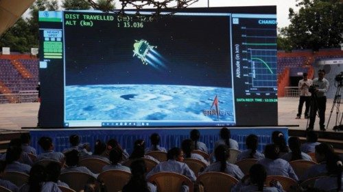 People watch a live stream of Chandrayaan-3 spacecraft's landing on the moon, inside an auditorium ...