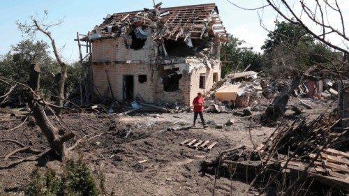TOPSHOT - A local resident walks past a crater and a destroyed residential house following a missile ... TOPSHOT - A local resident walks past a crater and a destroyed residential house following a missile ...