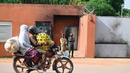 A moto-taxi carries a passenger past the French Embassy in Niamey on August 28, 2023. Thousands of ...