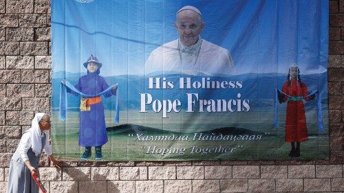 A nun installs a poster with an image of Pope Francis outside the bishops house, where he is ...