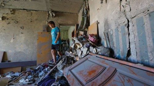 A local resident walks through the rubble in his neighbours' flat damaged by recent shelling in the ...