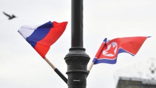 Flags of Russia and North Korea are seen fixed on a lamp post in front of the railway station where ...