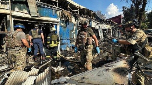 Police officers and rescuers inspect the site of a Russian military strike, amid Russia's attack on ...