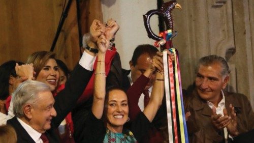Former Mexico City Mayor Claudia Sheinbaum reacts with the ceremonial baton of command with Mexico's ...