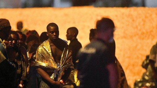 A migrants wraps himself in survival blankets as migrants wait on the Italian island of Lampedusa, ... A migrants wraps himself in survival blankets as migrants wait on the Italian island of Lampedusa, ...