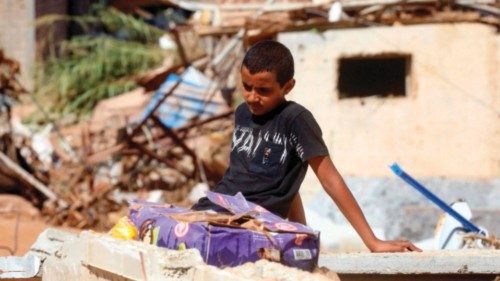 A young boy sits amid the rubble of a building destroyed in flash floods after the Mediterranean ...