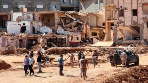 People walk in front of buildings that collapsed during floods after the Mediterranean storm ...