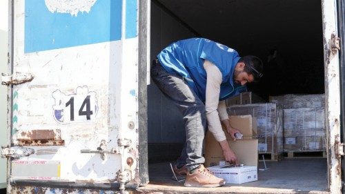 epa10869486 A volunteer checks aid material on a truck after entering the Bab al-Hawa border ...