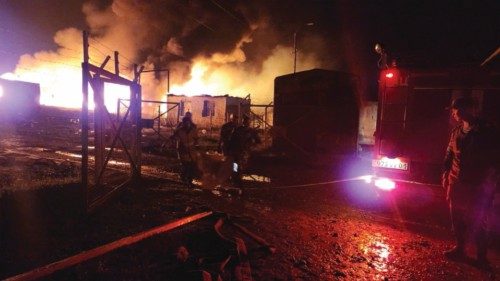 Rescue and medical personnel work following an explosion in the gasoline warehouse near the ...