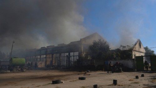 Police officers and firefighters work at a site of warehouses damaged during a Russian military ... Police officers and firefighters work at a site of warehouses damaged during a Russian military ...