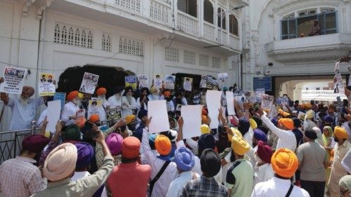 People hold placards protesting the killing of Canadian Sikh separatist leader Hardeep Singh Nijjar ...