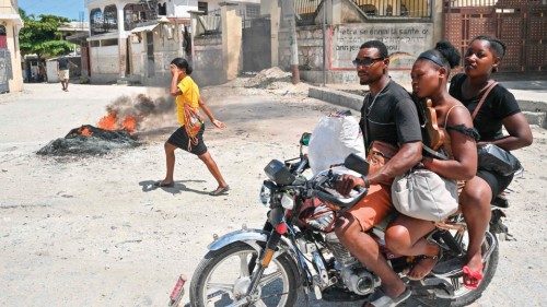 (FILES) A motorcyclist passes by burning tires as people demonstrate over the rise in the cost of ...