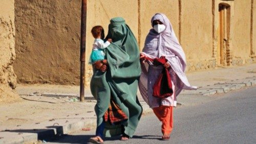 Afghan women along with a child walk along a street on the outskirts of Kandahar province on October ...