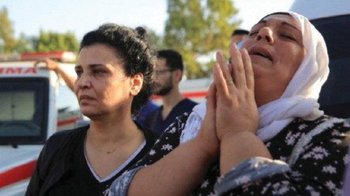 Relatives react outside a military hospital, during the funeral for scores of people killed in an ...