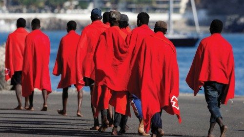FILE PHOTO: A group of migrants walk in the port of Arguineguin to be assisted by the Red Cross ...