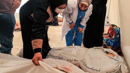 EDITORS NOTE: Graphic content / People inspect to identify one of the bodies of victims of the ...