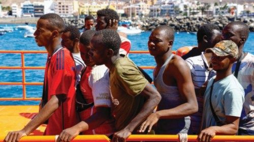 Migrants wait to disembark from a Spanish coast guard vessel, in the port of Arguineguin, on the ...