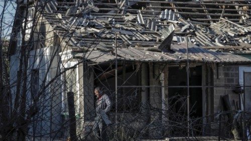 A local resident is seen outside a house damaged by a Russian drone strike, amid Russia's attack on ...