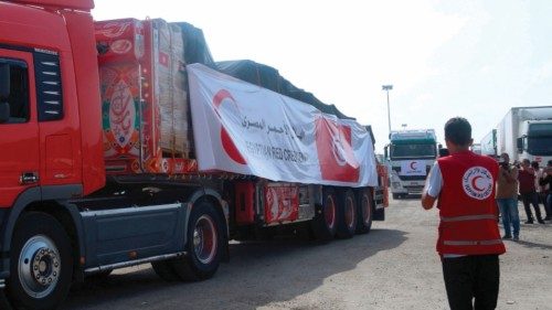 A volunteer from the Egyptian Red Crescent looks on as a convoy of lorries carrying humanitarian aid ...