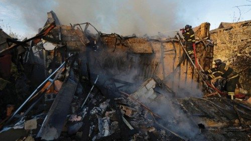 Firefighters work to put out fire at a house that was hit by shelling in the course of ...