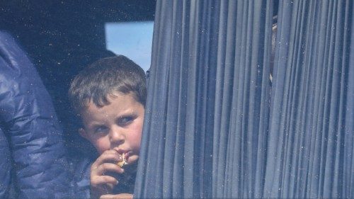 FILE PHOTO: A boy looks through a window of a bus used by refugees fleeing Nagorno-Karabakh region ...