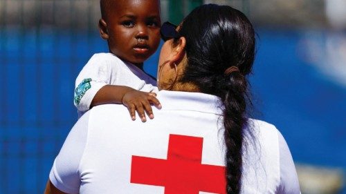A Red Cross volunteer cares for a migrant baby after disembarking from a Spanish coast guard vessel, ...