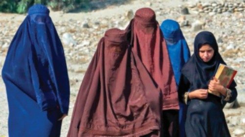 TOPSHOT - Afghan burqa-clad women walk along a street in the outskirts of Jalalabad on October 22, ...