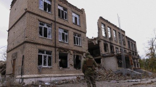 FILE PHOTO: A police officer stands in front of a damaged building, amid Russia's attack on Ukraine, ...