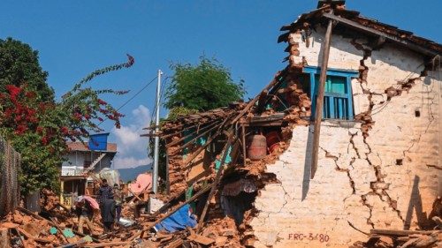 Survivors walk through the ruins of a damaged house following an earthquake in Khalanga of Jajarkot ...
