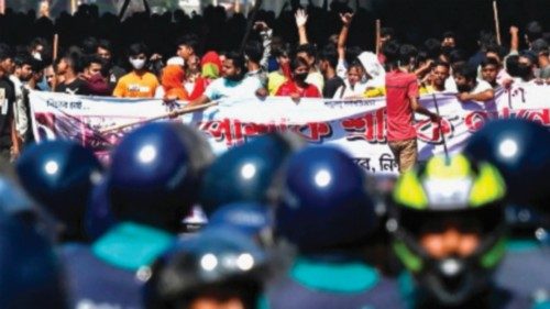 TOPSHOT - Bangladesh police (foreground) stand guard as garment workers protest to demand the ...