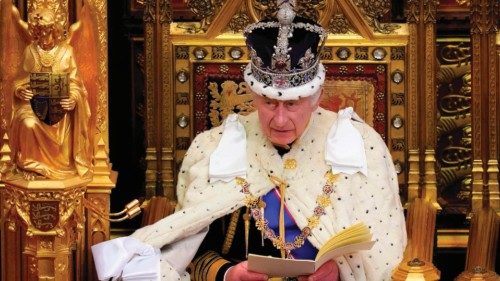 Britain's King Charles III, wearing the Imperial State Crown and the Robe of State, reads the King's ...