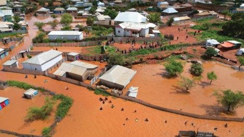 epa10960835 A picture taken with a drone of people walking in the flooded streets of Baidoa town, ...