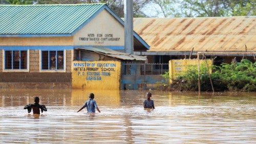 Children wade in floodwater outside the Hatata primary school following heavy rains at Mororo ...