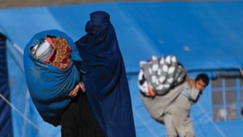 TOPSHOT - An Afghan refugee woman along with her children prepare to load her belongings on a ...