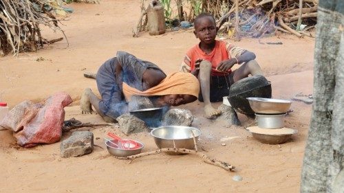 A girl in the Orang Sudanese refugee camp tries to set fire to cook food for her family, Chad, ...