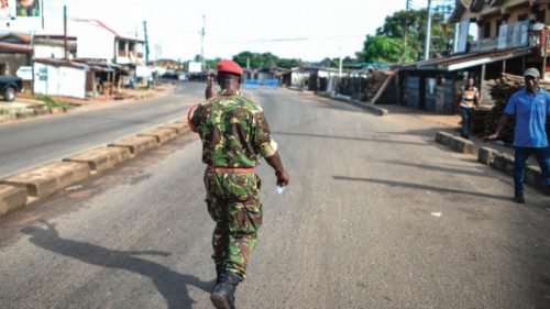 TOPSHOT - A Soldier with the Sierra Leonean military police greets and man along an empty road in ...