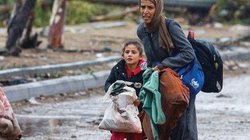 A barefooted Palestinian woman fleeing north Gaza with her daughter during rainfall moves southward ...