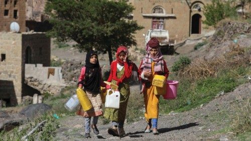Girls walk as they carry jerrycans to fetch water from a faucet in Bani Matar, Yemen, one of the ...